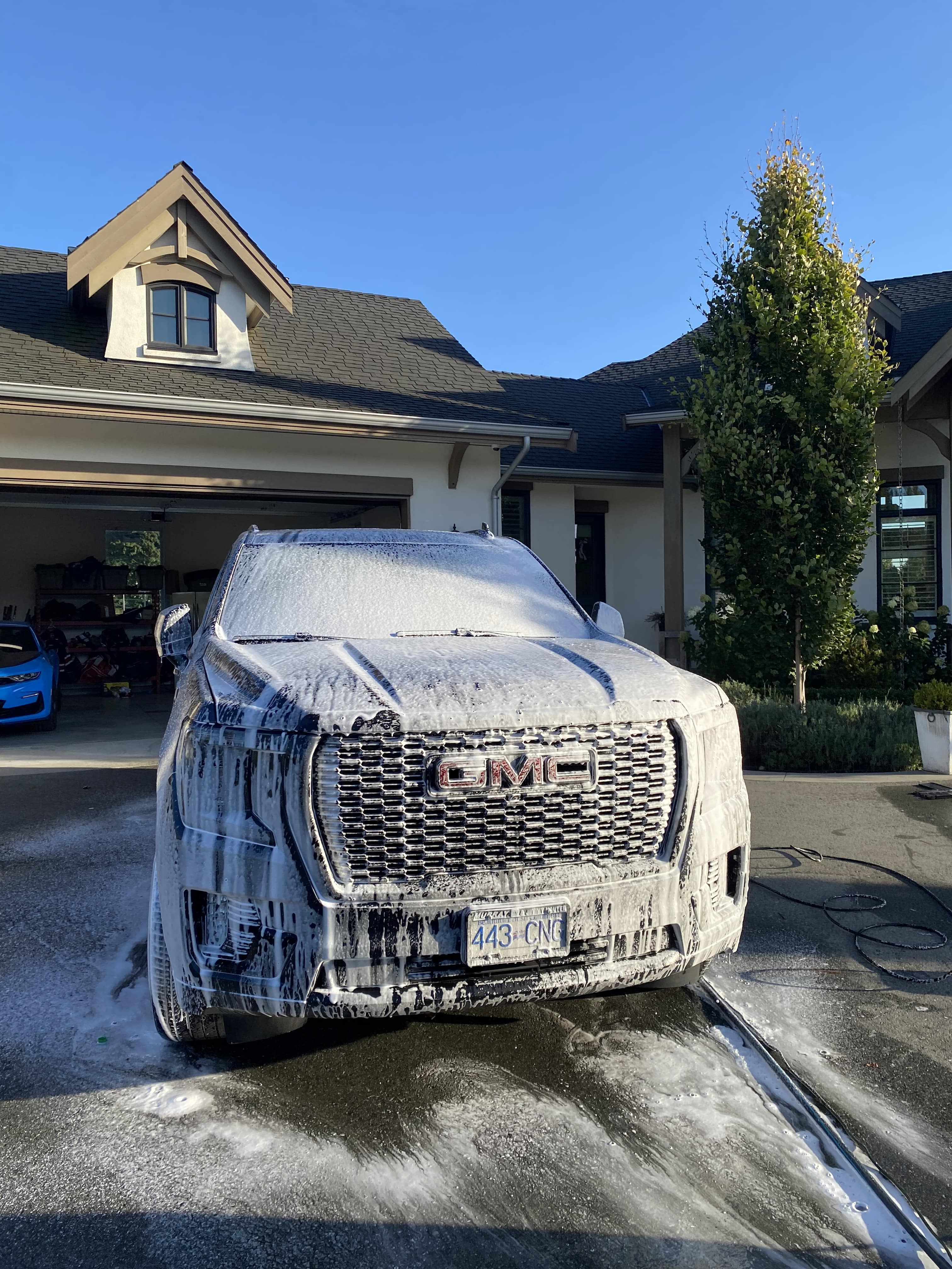 GMC SUV covered in snow foam during wash stage